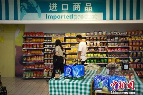 民众在超市进口商品货架前选购商品。　张云 摄
