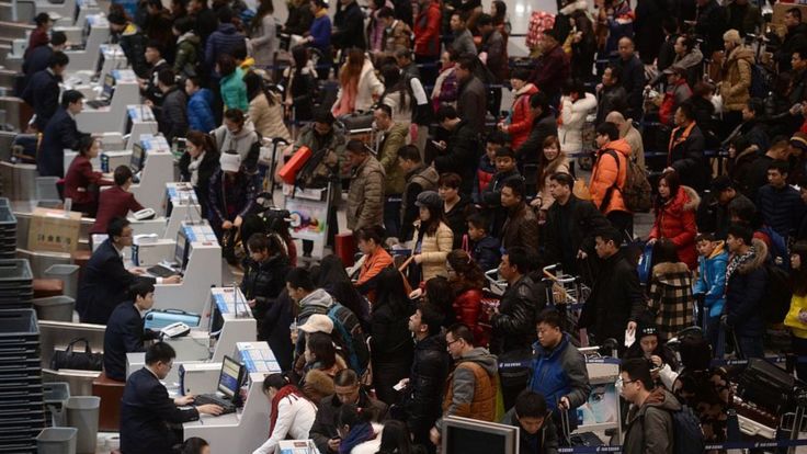 Passengers checking in at the service counters in Beijing Capital International Airport on the first day of China's spring festival travel rush in Beijing