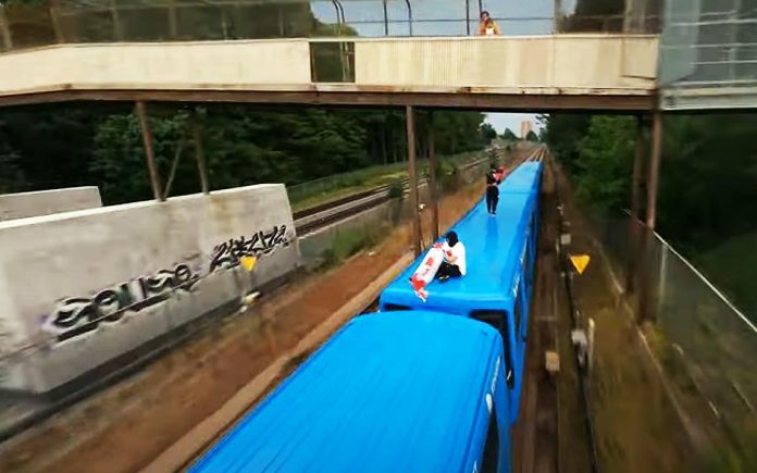 危险！两名蒙面人爬上行驶中的列车顶展示国旗拍视频